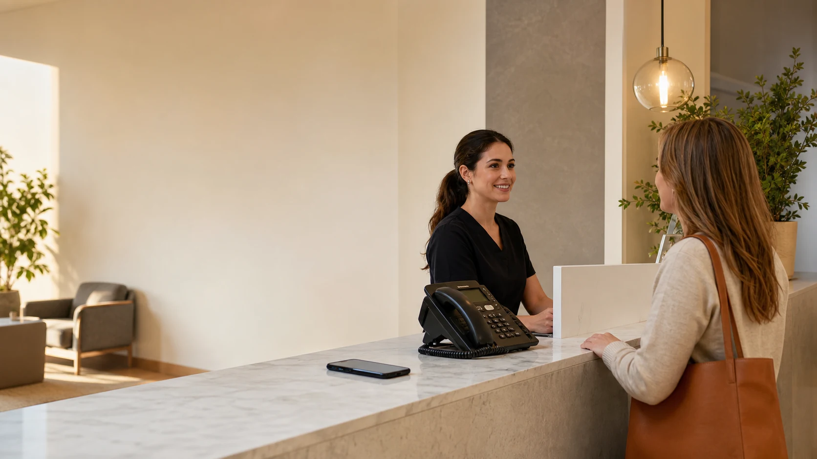 Dental office coordinator helping a patient while a business call is handled
